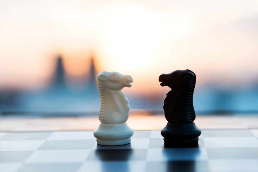 Chess board with two opposing knight pieces in the middle
