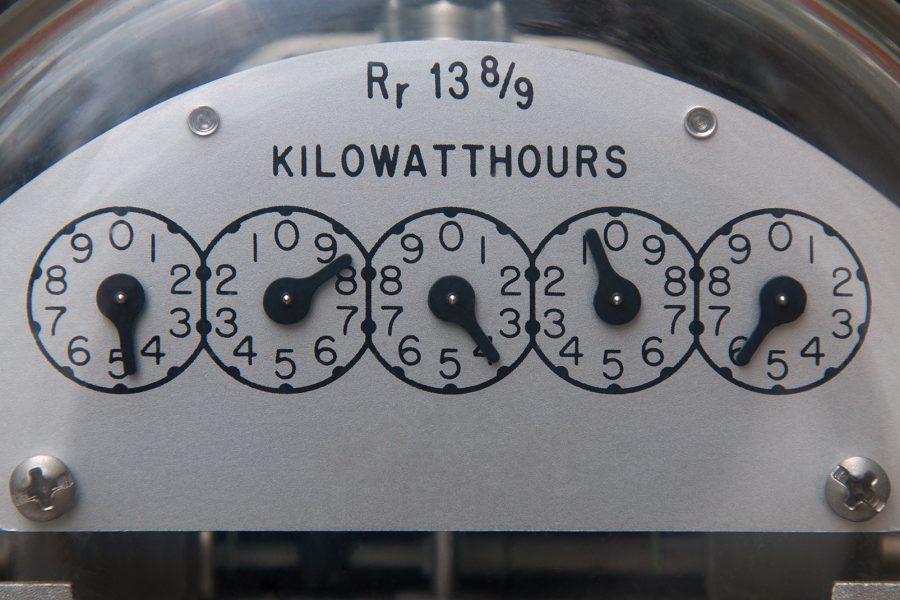 Close up image of an electric meter displaying the kilowatts per hour dials