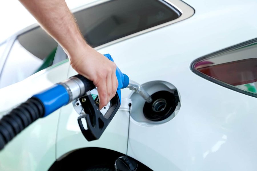 Closeup of man pumping gasoline in a car at gas station