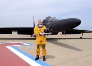 Paul Gourley in a flight suit stands in front of a military aircraft