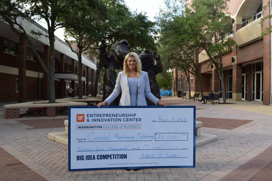 Shelby Thomas holds a giant check for $25,000