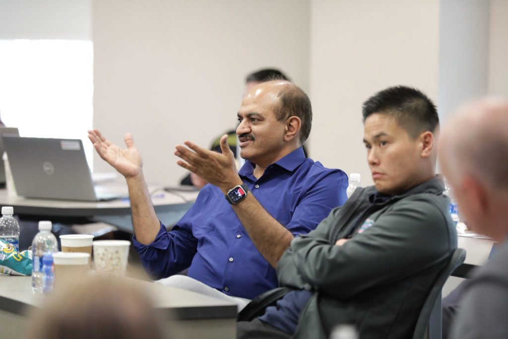 Students asking questions in a conference room.