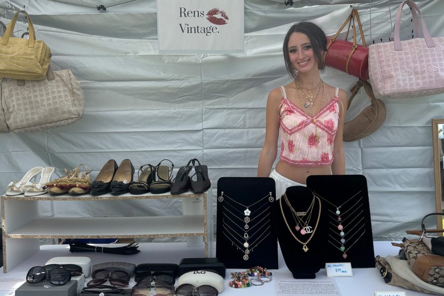 Lauren Kurtz smiling in a booth, reselling luxury goods for her business Rens Vintage at a vintage market.