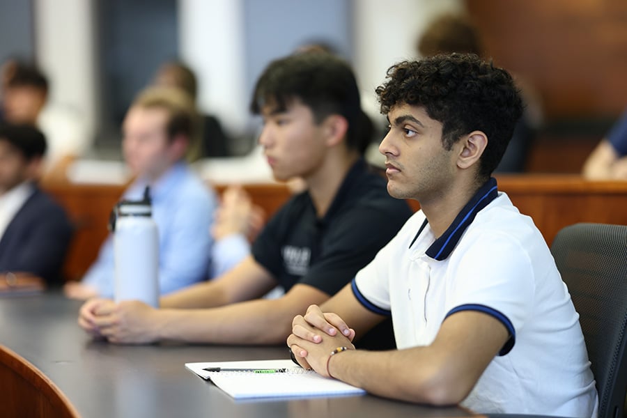 Young men that are college students attending a lecture.