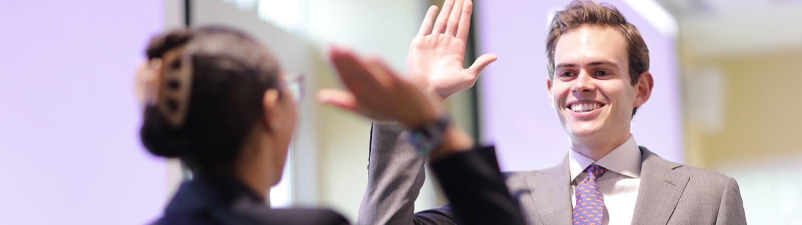 Two UF Warrington College of Business students high-five each other during a challenge hosted by the Bergstrom Real Estate Center