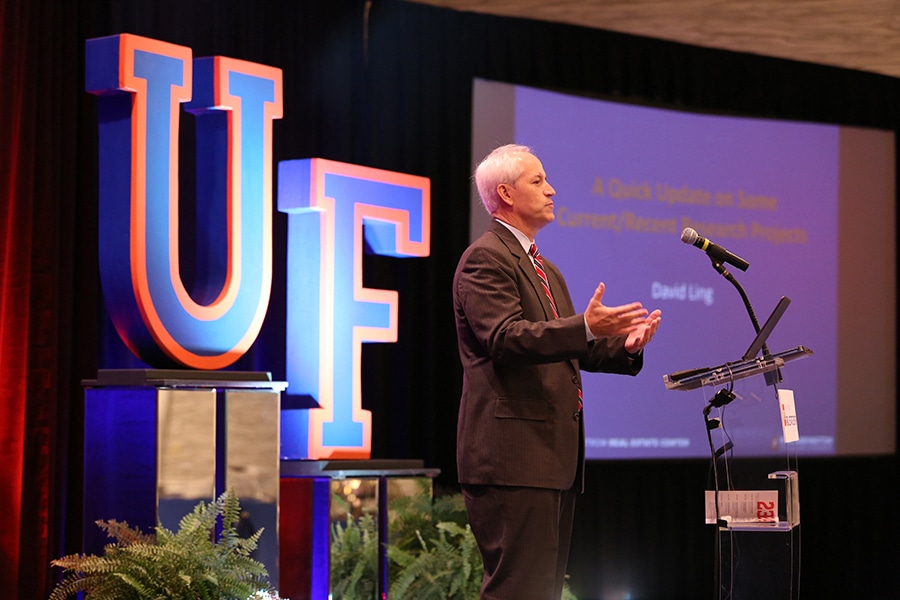 A researcher from the University of Florida Warrington College of Business' Bergstrom Real Estate Center presents his findings while standing behind a podium and using a slide presentation