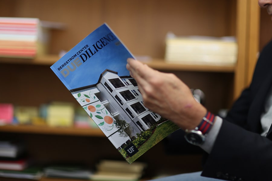Hands opening a copy of Due Diligence, the publication for the UF Warrington College of Business' Bergstrom Real Estate Center