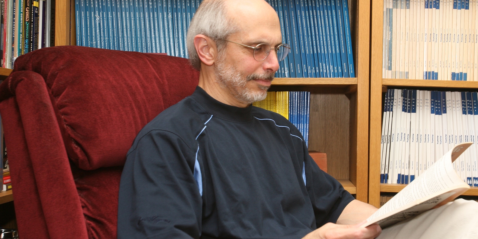 A faculty member from the University of Florida Warrington College of Business reads published research in a library setting