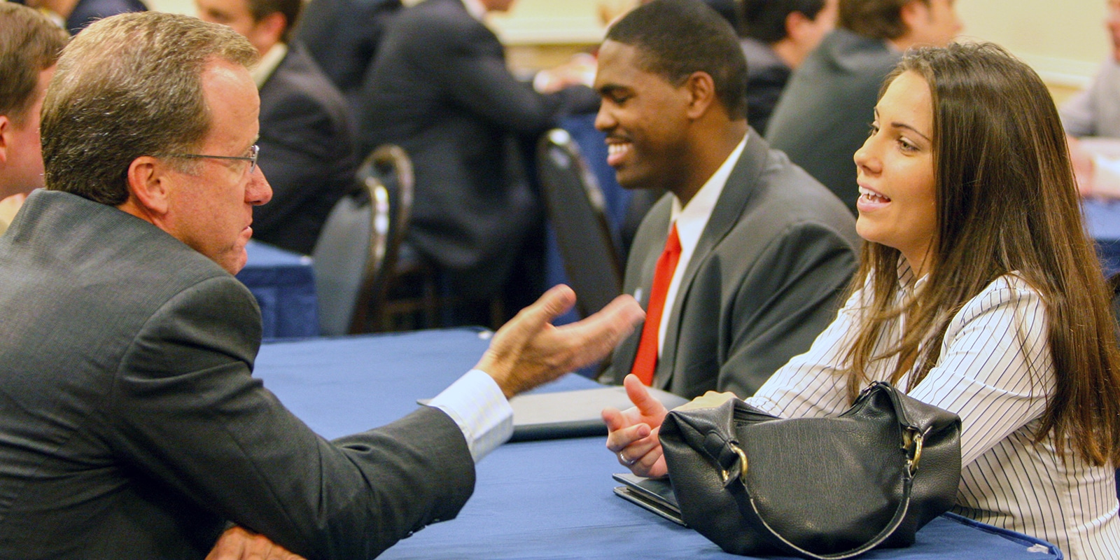 Sitting at tables, UF Warrington Full-Time MBA students speak with recruiters