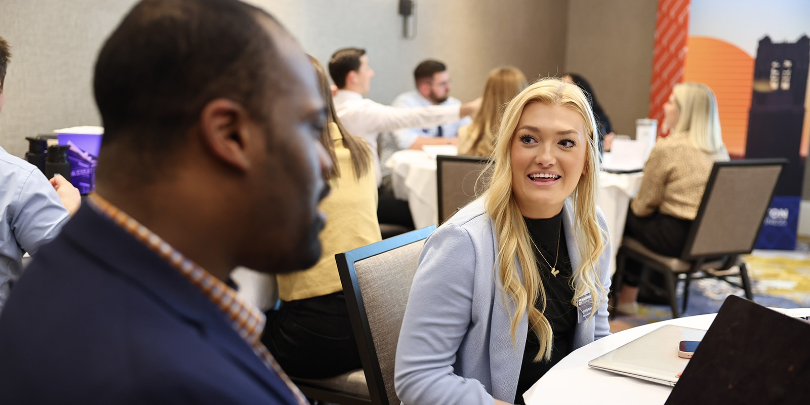 Sitting around tables, students from University of Florida's MBA programs converse during a Summit Series event