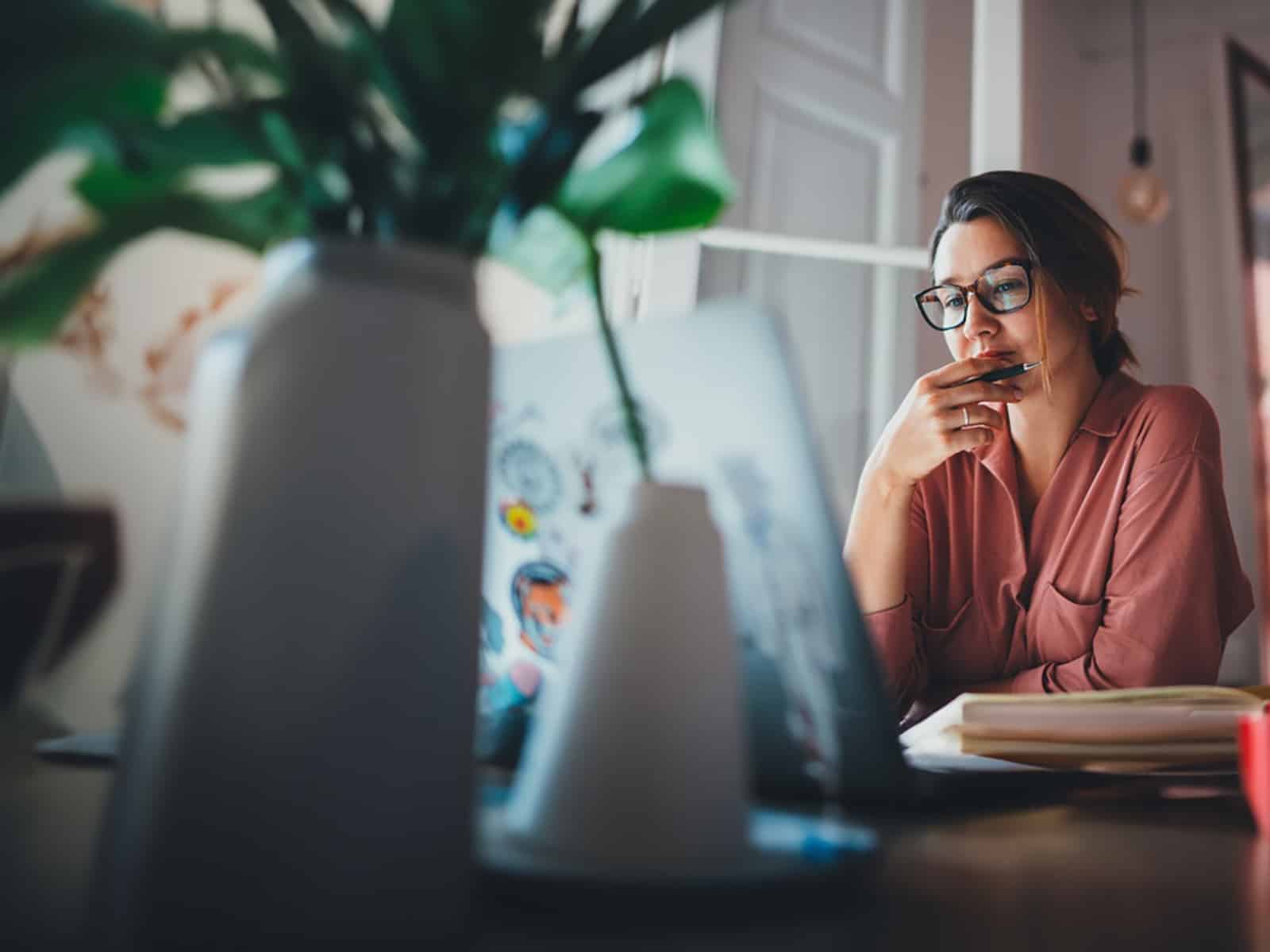 A student enrolled in the University of Florida Warrington College of Business' Online MBA program reviews coursework on their laptop at home
