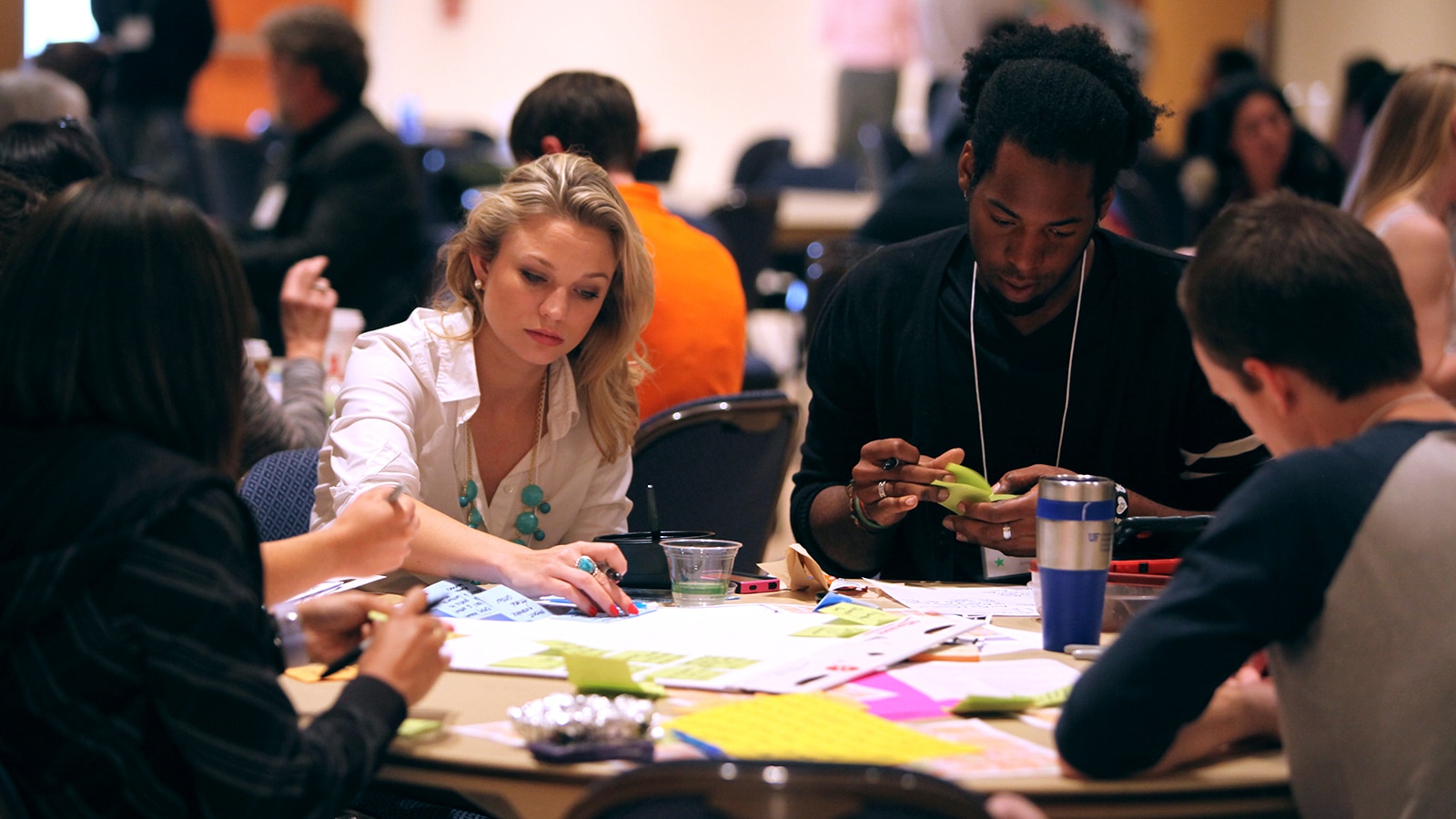 University of Florida Warrington College of Business collaborate on a group entrepreneurial project, outlining their ideas with colorful Post-It notes