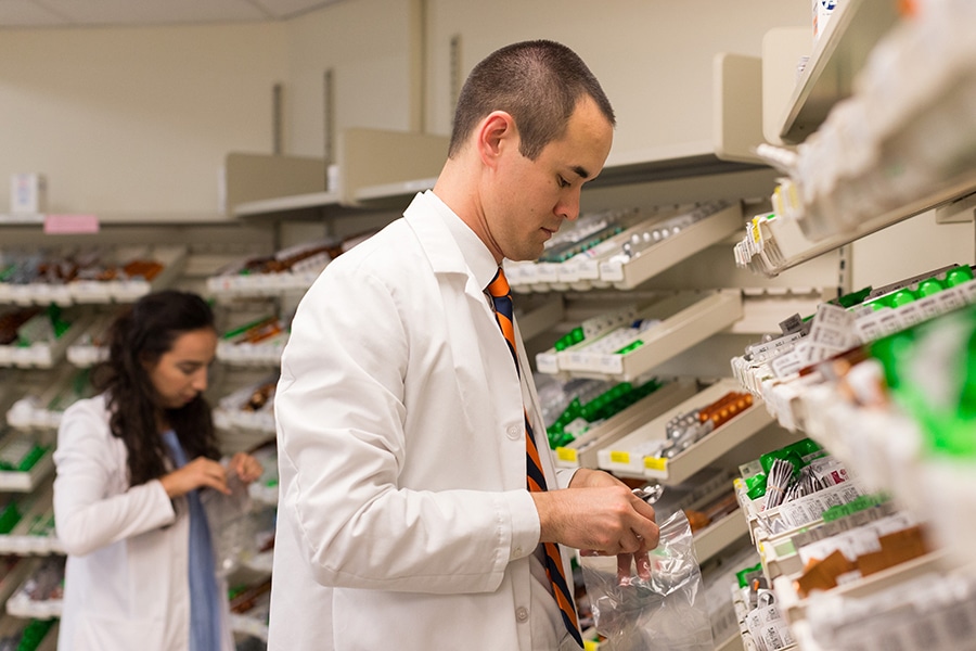 Students enrolled in the University of Florida Warrington College of Business' PharmD/MBA program sort through medications in a pharmacy setting