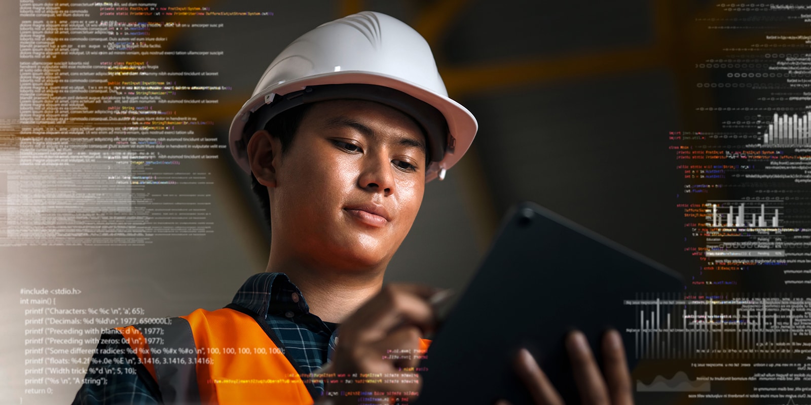 A student from the University of Florida Warrington College of Business' MS in ISOM in Supply Chain Management program wears a hard hat while using a tablet, with code in the foreground
