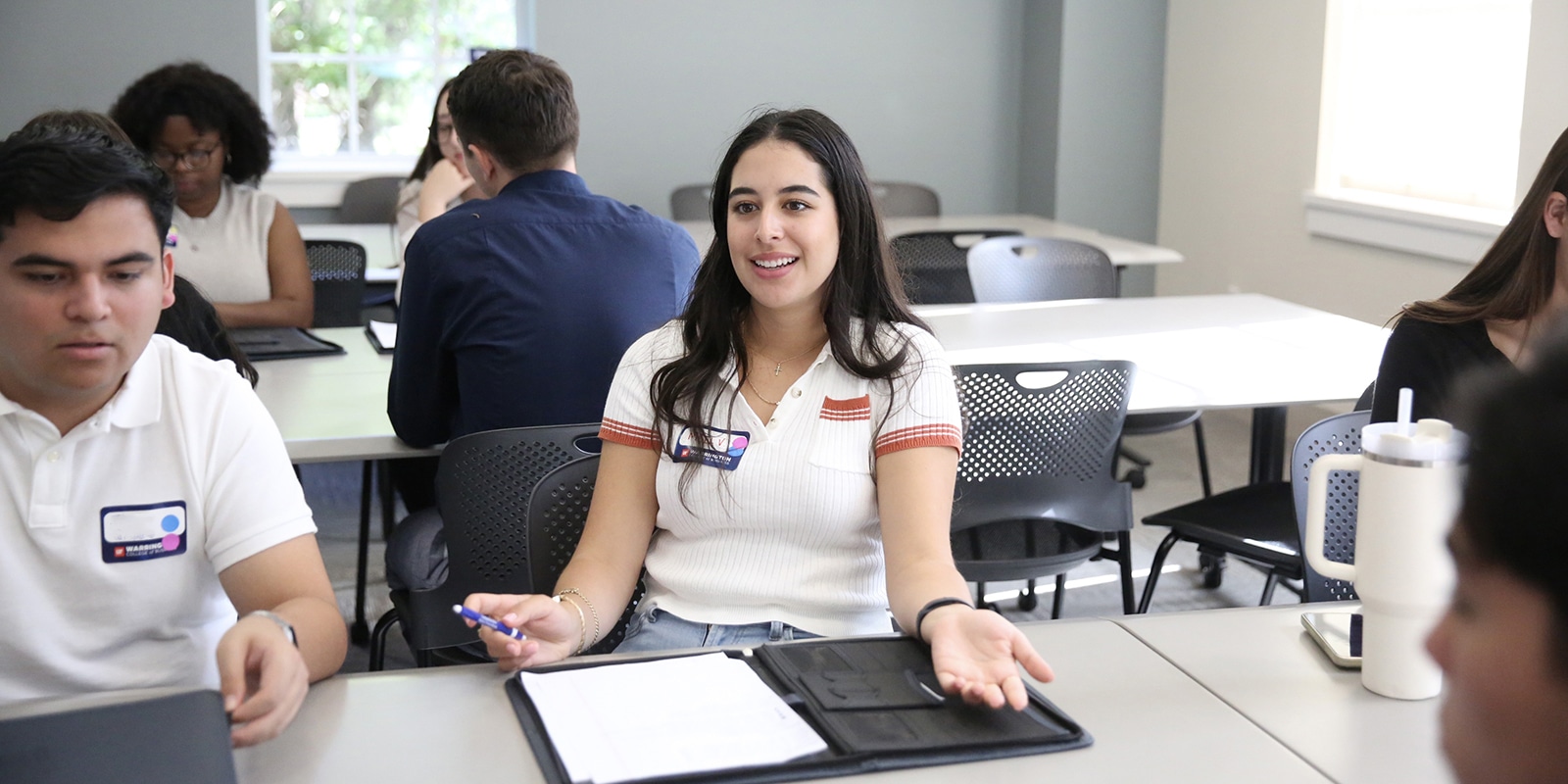 A group of students from the Warrington College of Business, including MSM students, discuss their GatorNest projects in groups
