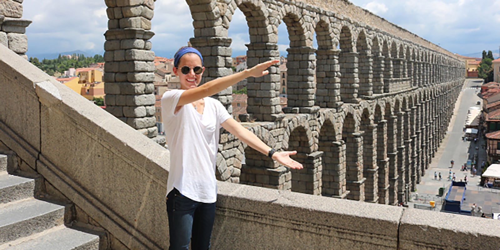 A student from the University of Florida Warrington College of Business' Master of International Business program makes Gator arms in front of an aqueduct during a study abroad trip