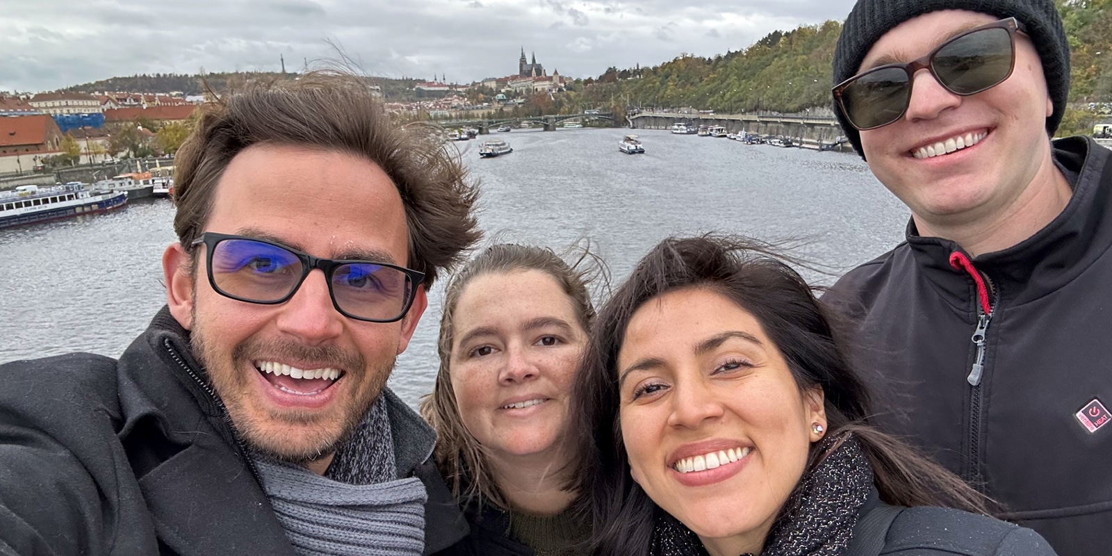 During a Global Immersion Experience, four students from UF Warrington's Weekend Part-Time MBA program pose in front of a canal with barges