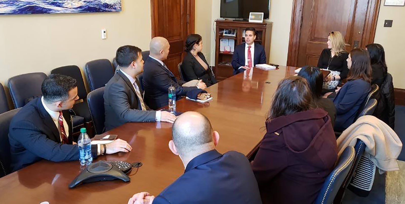 A group of students from University of Florida's MBA program sit around a table while listening to a policymaker's presentation during a Washington Campus session