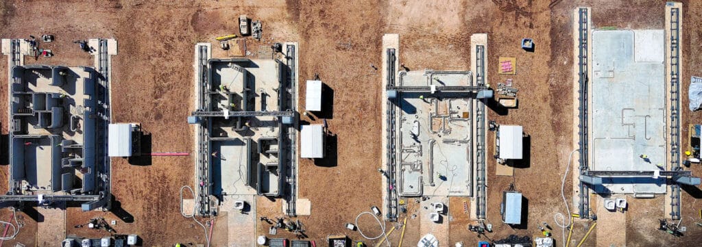 Aerial view looking straight down at the foundations of four houses being 3D printed
