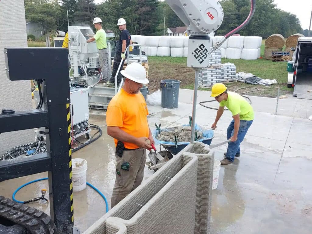 Workers on a construction site working around the 3D wall printing