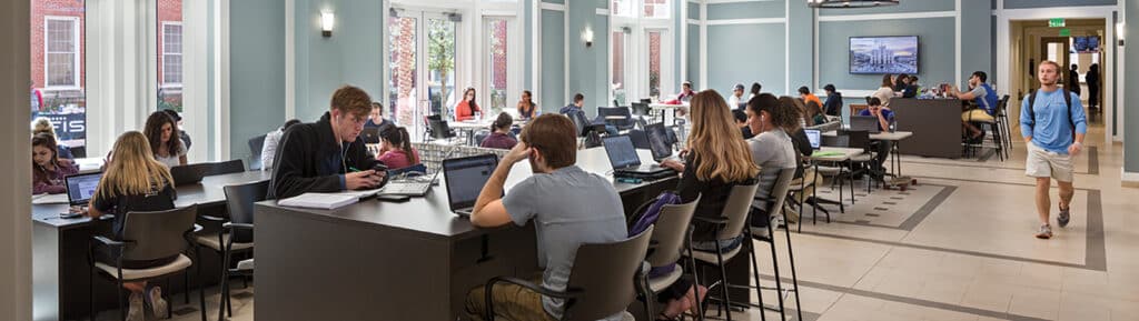 BABA and other UF Warrington undergraduate students study at tables in a sunlit common area