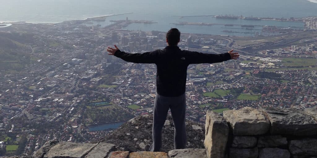 A student from UF Warrington's BSBA in Information Systems program stands with their arms outstretched while standing on an overlook during a study abroad trip
