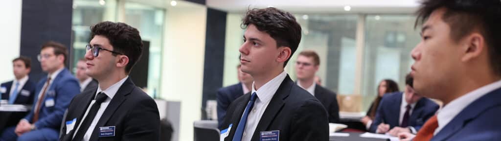 Students enrolled in the University of Florida Warrington College of Business' BSBA in Management program wear suits while sitting in a classroom