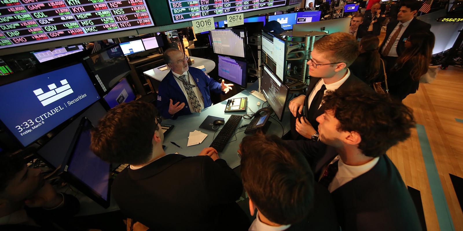 Students listening to a speaker on Wall Street. 