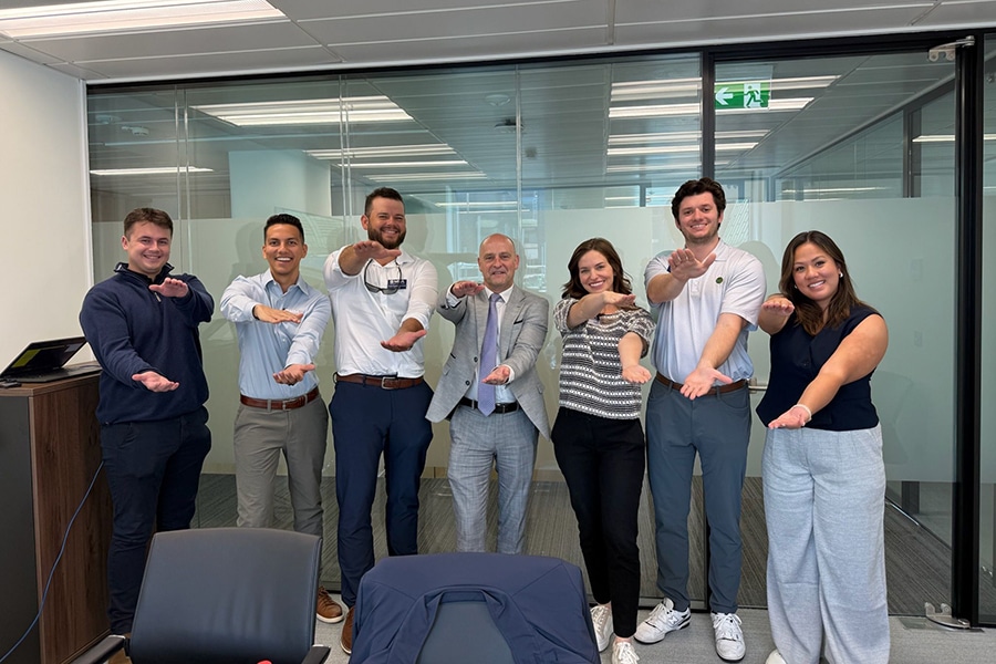 Students doing the gator chomp in an office. 