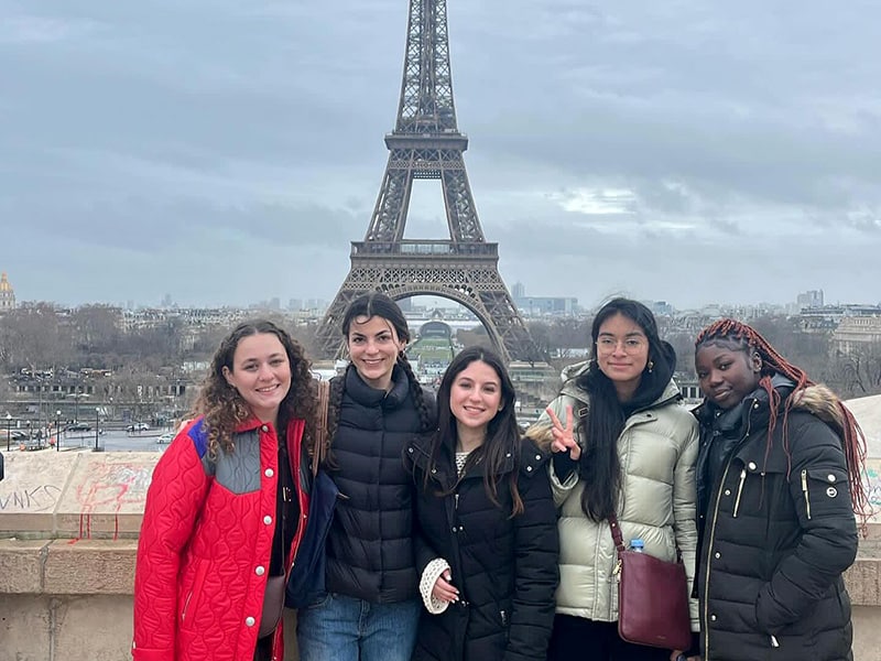 Heavener students studying abroad in Paris, France posing in front of the Eiffel Tower.