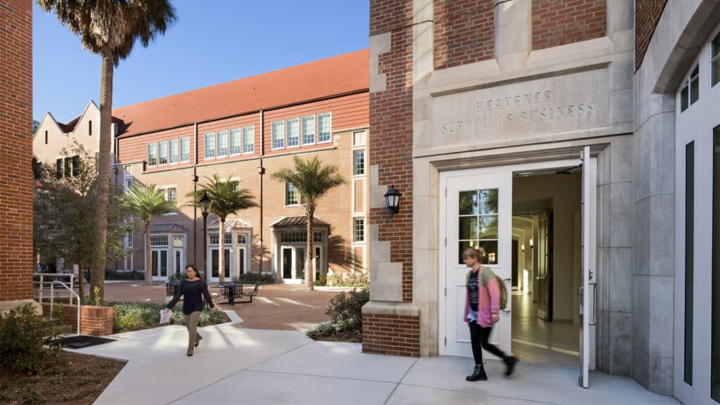Heavener Hall's south entrance and courtyard with students walking by.