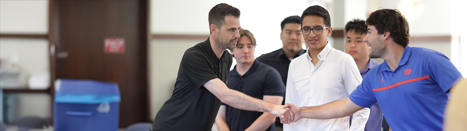 A representative from UF Warrington's MS in Business Analytics program shakes hands with a student from a competing team following a competition