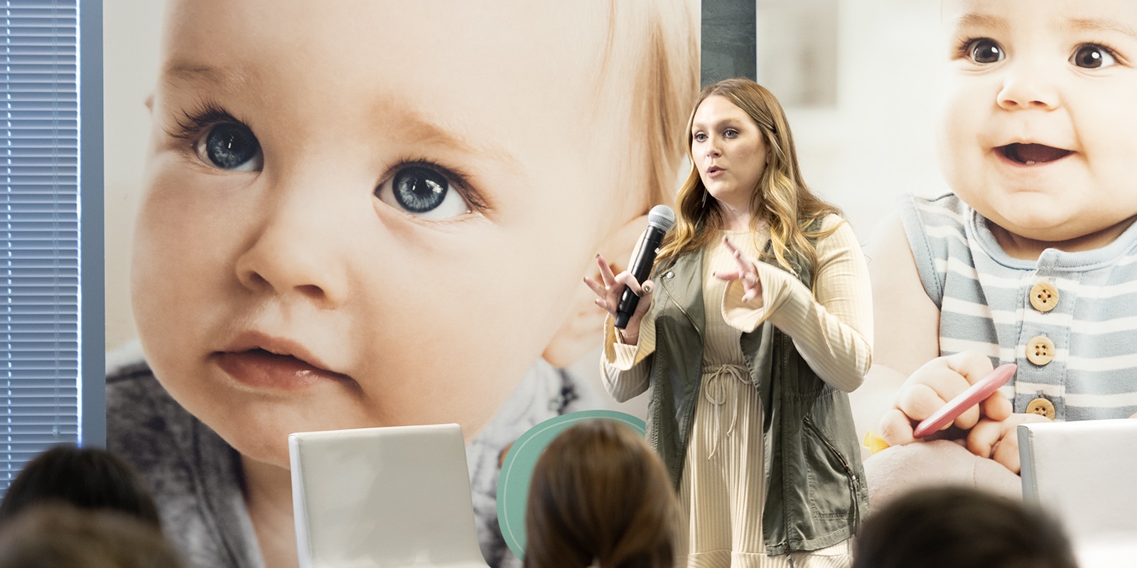 Standing in front of a screen with images of babies, a student from UF Warrington's MS in Business Analytics program discusses her team's project