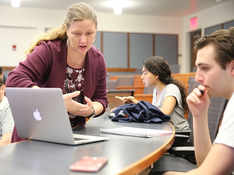 Professor Megan Mocko in class working with a student. 