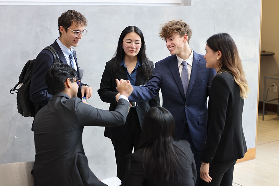 Group of students shaking hands. 