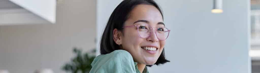 A student using a laptop smiles while reviewing coursework for the University of Florida Warrington College of Business' Online BABA program