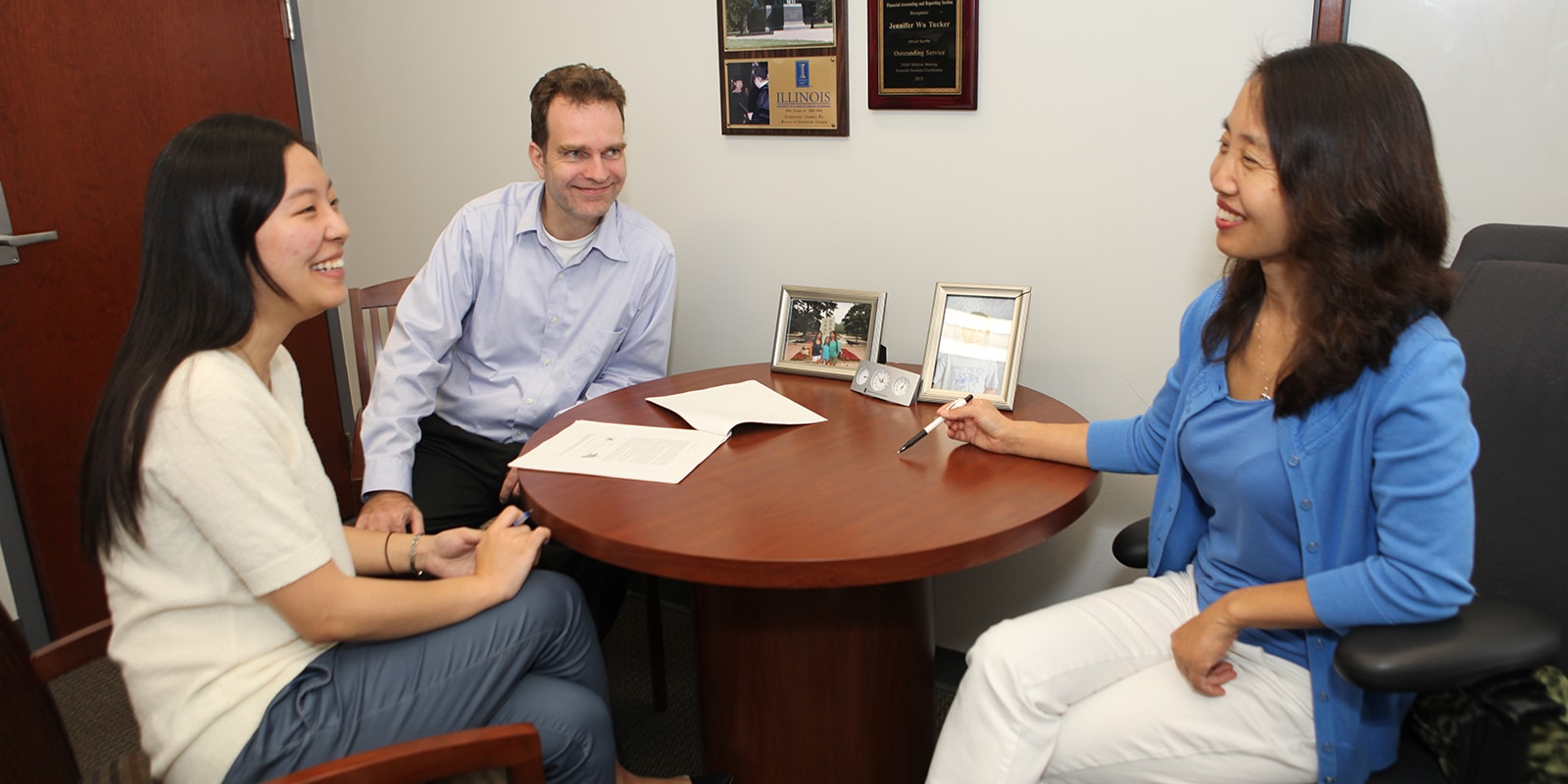 Students in UF Warrington's PhD in Accounting program sit around a table to discuss their first-year summer research projects