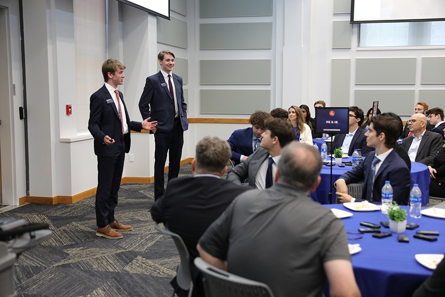 FinTech students presenting to a room of attendees. 