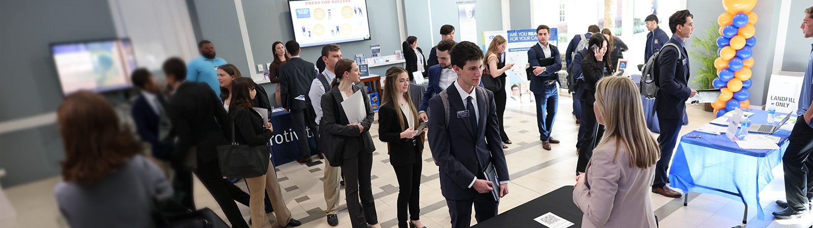 Students interacting with recruiters at a career fair.