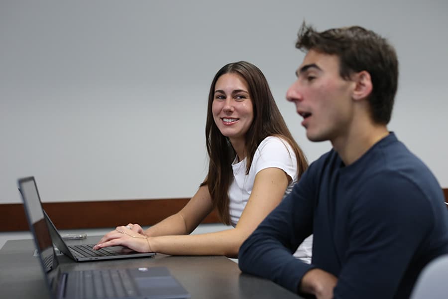 Happy students using laptops in class.