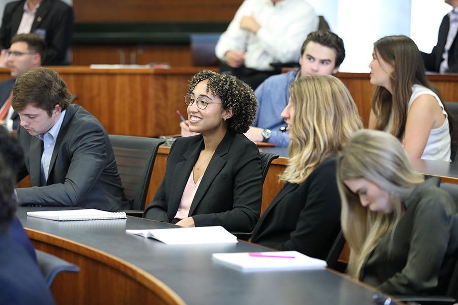 Business students sitting in class with the focus on a smiling young woman.