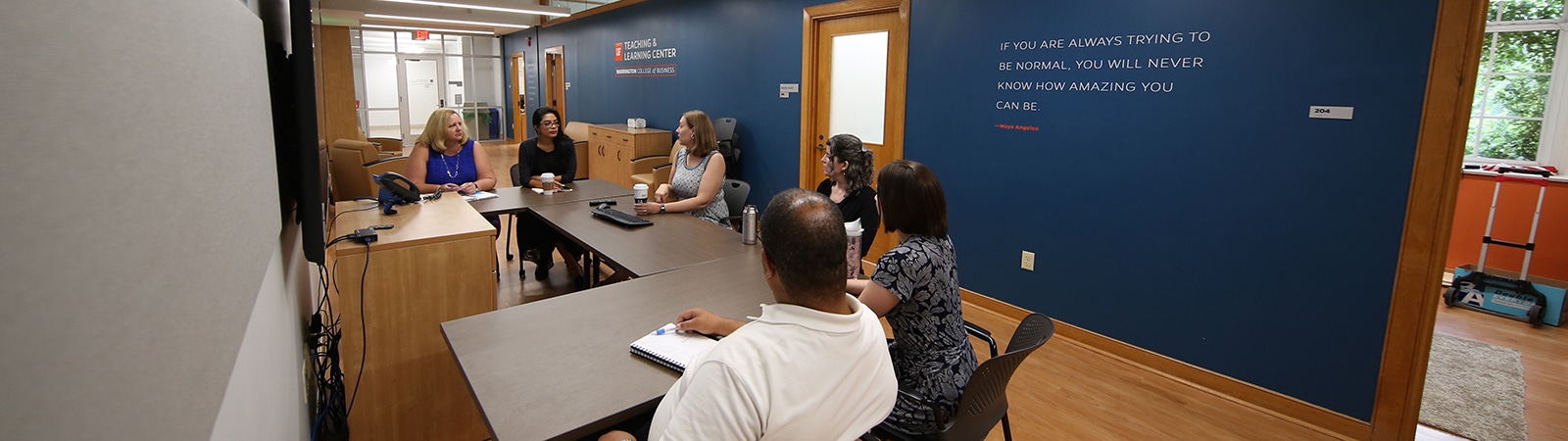 Teaching and Learning Center staff gathered around a table in their office space. 