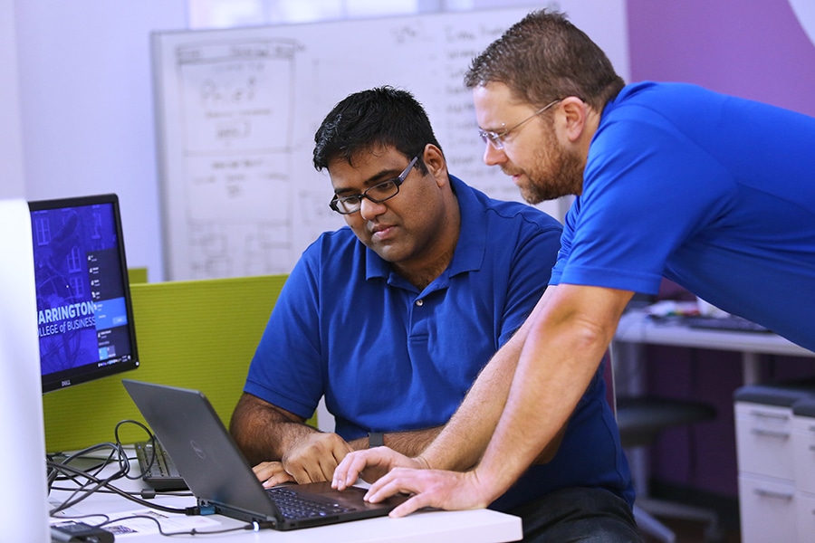 A student and faculty member review data on a laptop in the Gator Hatchery, a student incubation space managed by the University of Florida Warrington College of Business