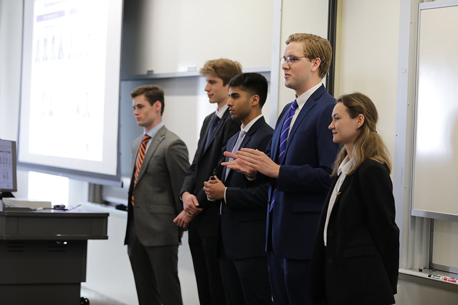 Wearing suits, Warrington College of Business undergraduates who participated in the Gator Student Investment Fund present their portfolio strategy to an audience
