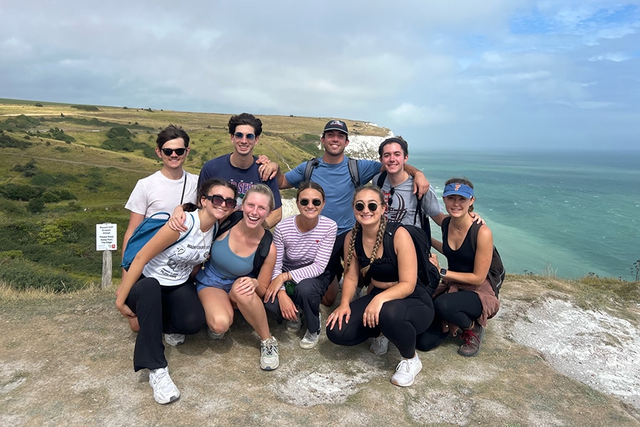 A group of UF Warrington College of Business students stand near a scenic overlook during a study abroad trip