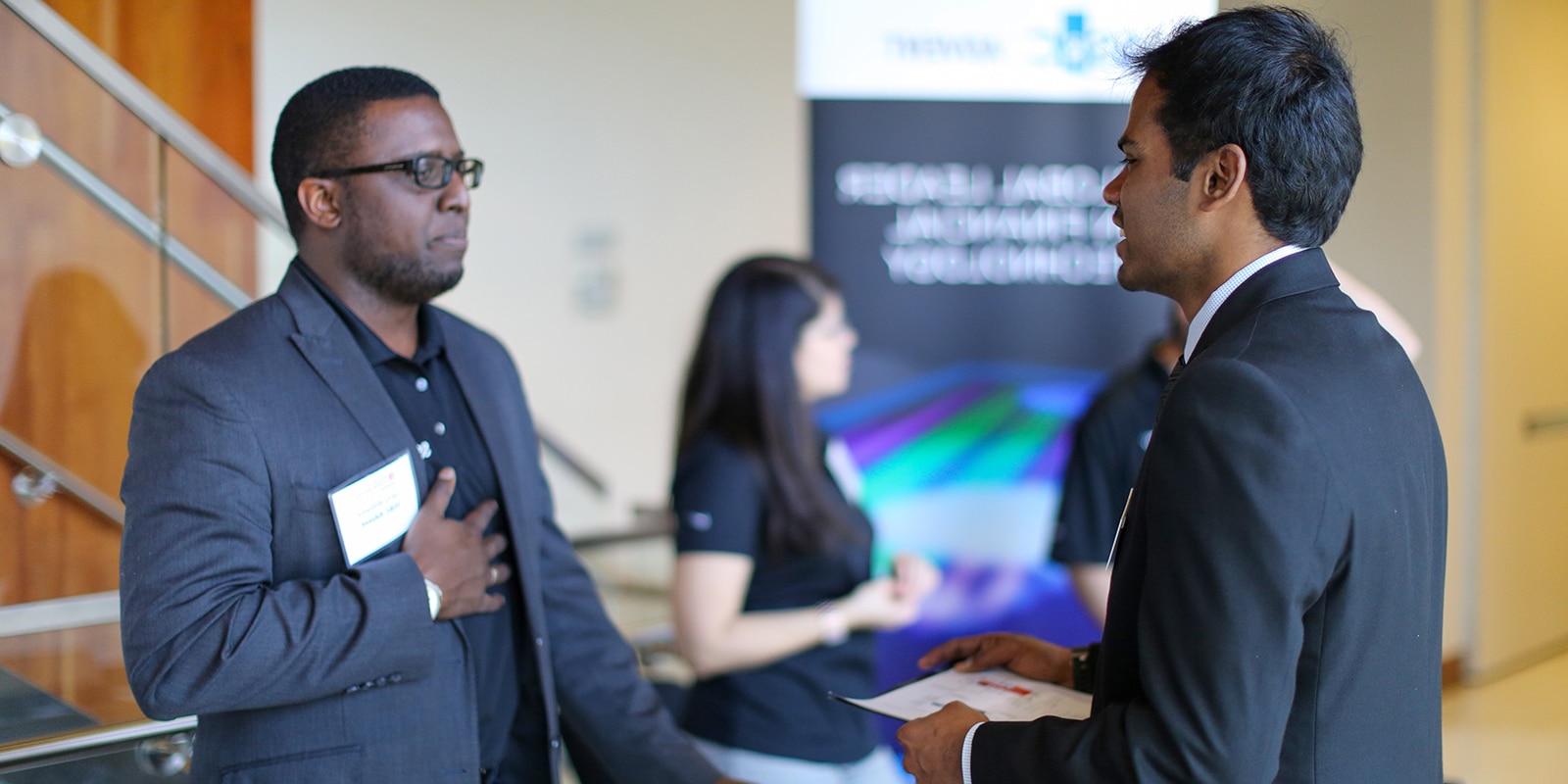 A student from UF Warrington's Part-Time Weekend MBA program holds a resume while speaking with a recruiter during a career fair