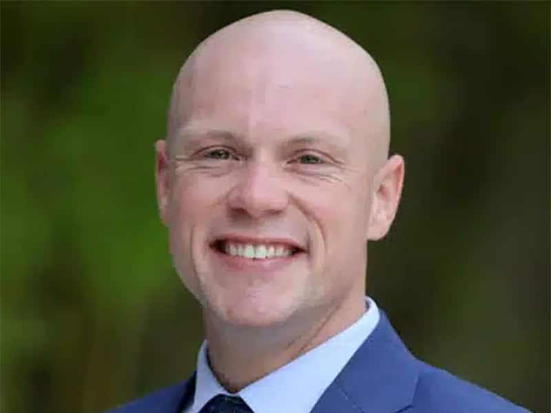 Portrait of smiling UF MBA student and U.S. Army veteran in a blue suit