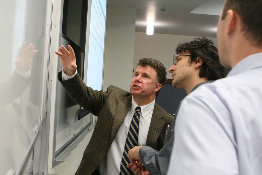 professor teaching students using a whiteboard