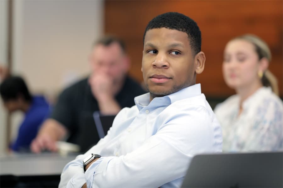 Business student listens attentively during an on-campus MBA class