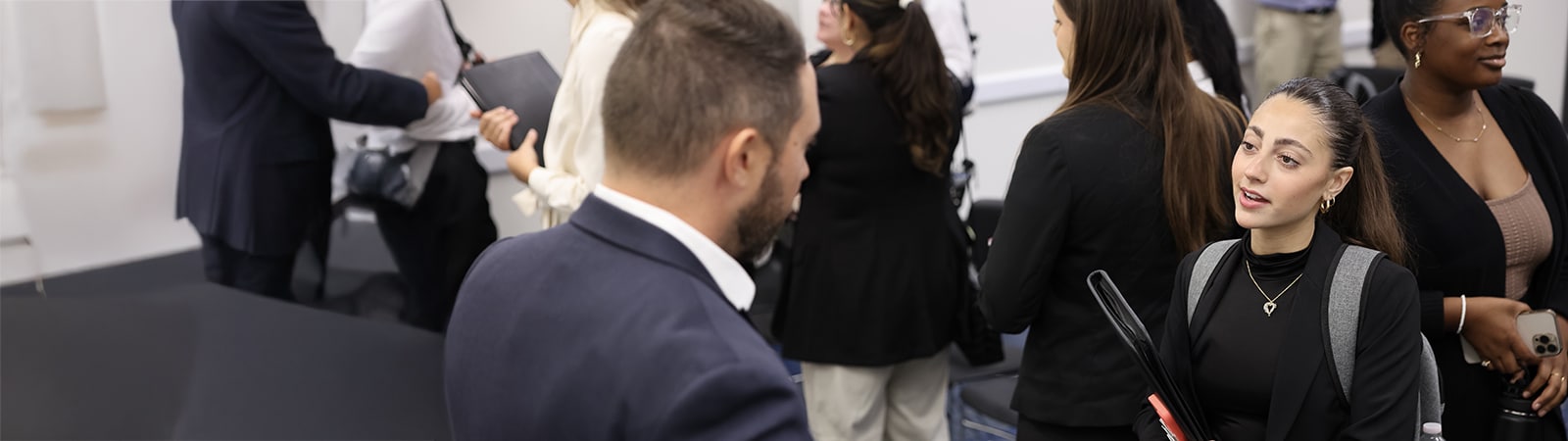 A female graduate student speaking to a male recruiter at an event. 